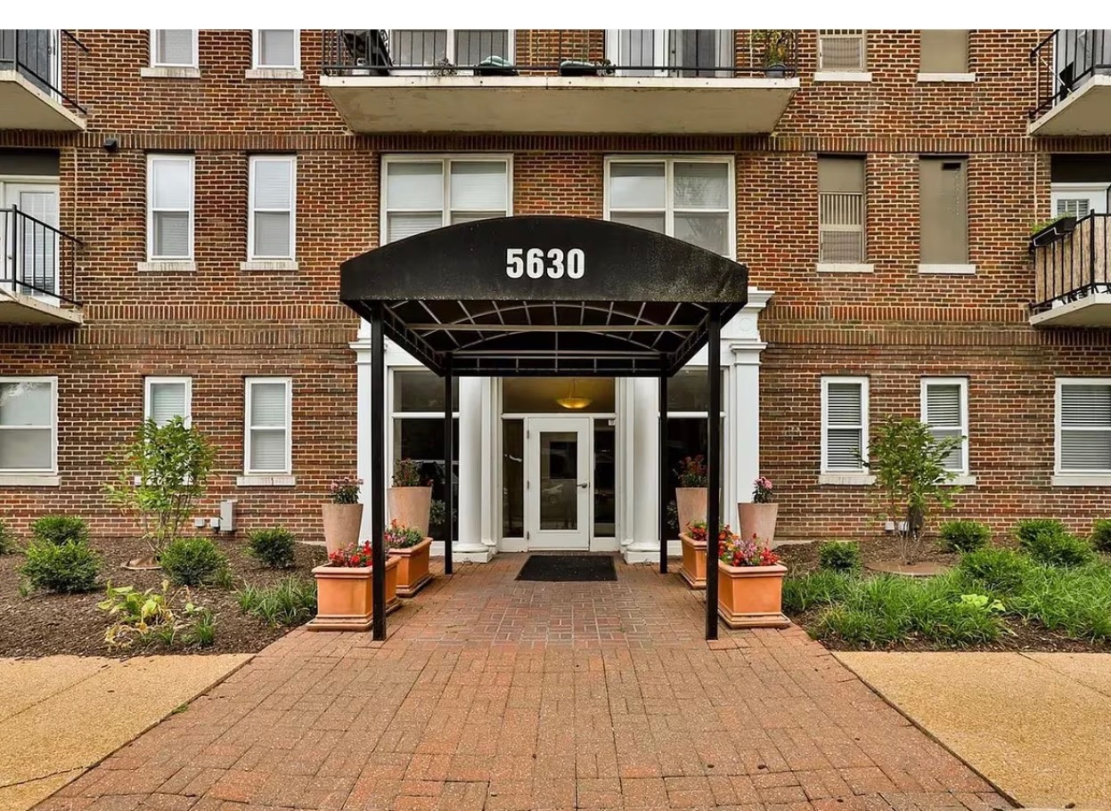 Front entrance of 5630 Pershing Ave, Saint Louis MO, with historic brick facade and black canopy over the entryway