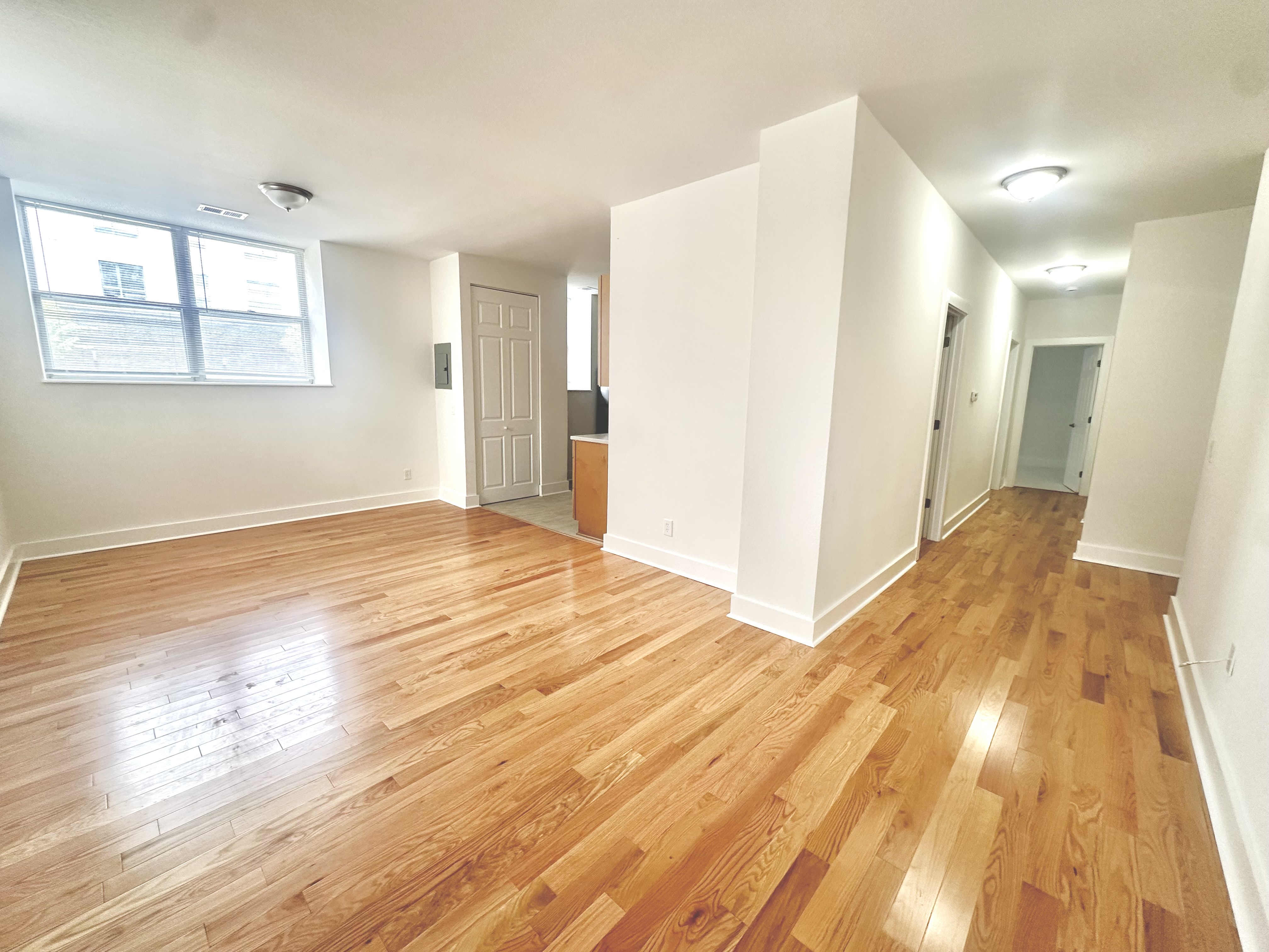 Living area with warm oak hardwood flooring and natural light