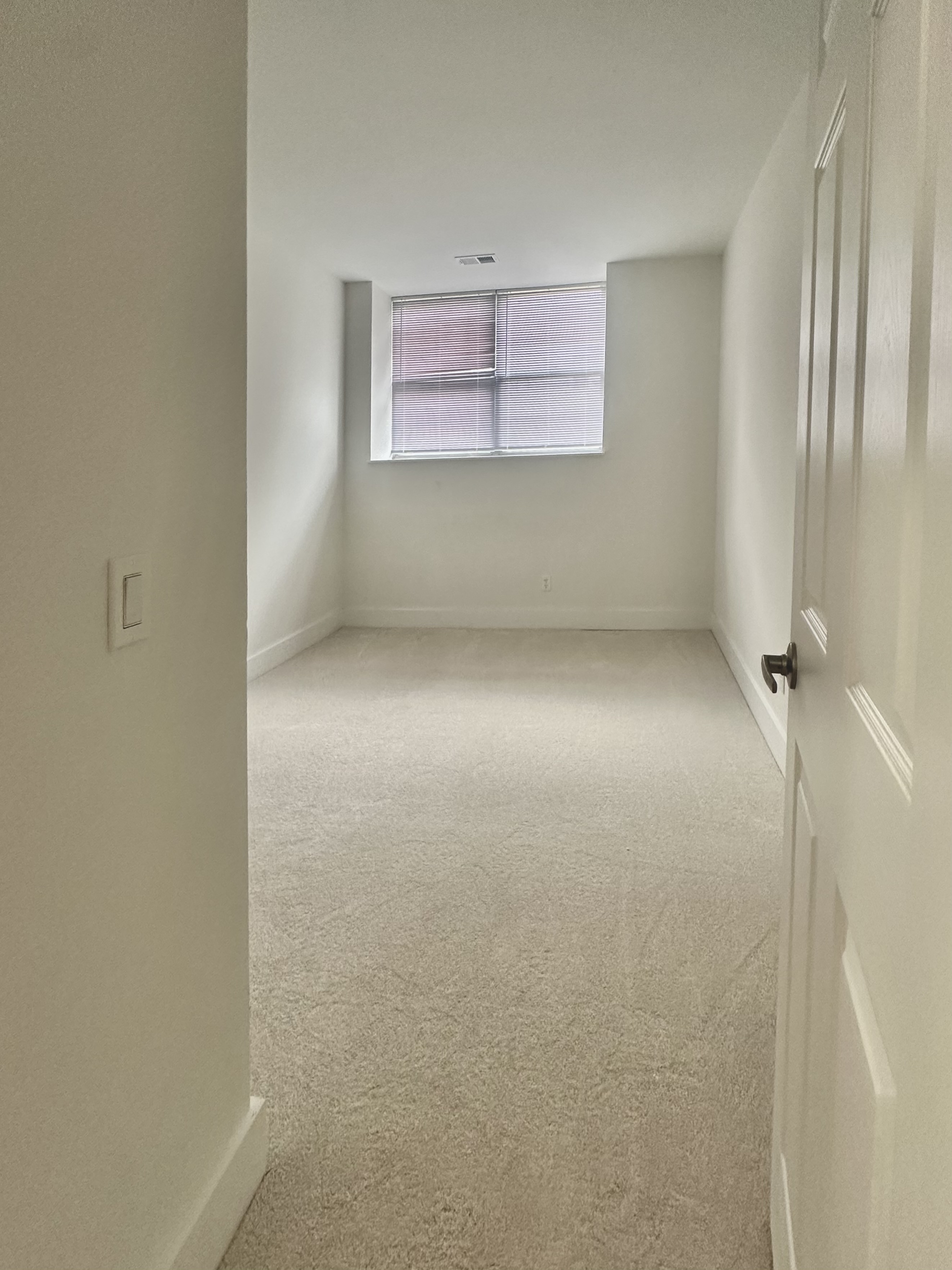 Bedroom with window, plush carpeting, and neutral walls
